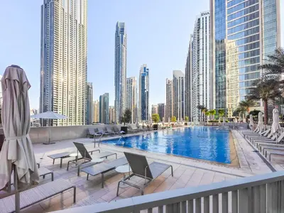 a swimming pool in the middle of a city with tall buildings at the London Condo - Forte Downtown Dubai in Dubai