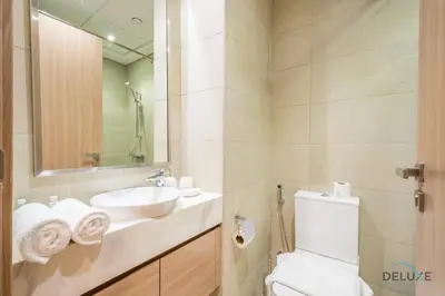 a bathroom with a sink and a toilet and a mirror at Inviting 1BR Apartment in Azizi Riviera 32, Al Merkadh by Deluxe Holiday Homes in Dubai