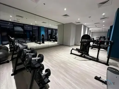 a gym with a row of treadmills and mirrors at Inviting 1BR Apartment in Azizi Riviera 32, Al Merkadh by Deluxe Holiday Homes in Dubai
