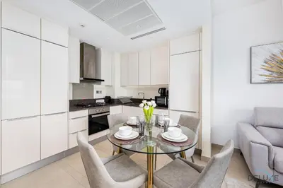 a kitchen and dining room with a table and chairs at Chic 1BR in The Residence at Marina Gate 2, Dubai Marina by Deluxe Holiday Homes in Dubai