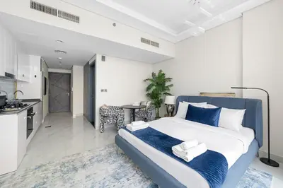 a bedroom with a large bed and a kitchen at Cozy Studio with sun terrace in Dubai