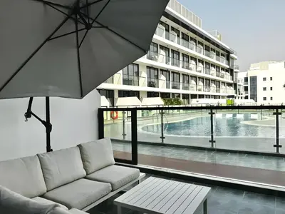 a living room with a couch and an umbrella at Cozy Studio with sun terrace in Dubai