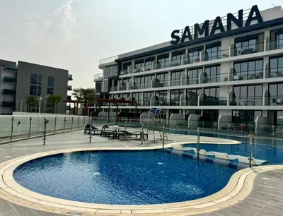 a large building with a swimming pool in front of it at Cozy Studio with sun terrace in Dubai