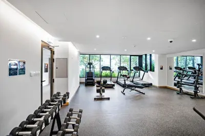 a gym with chairs and treadmills in a house at 5 min to Metro - New 1 Bed in Business Bay in Dubai