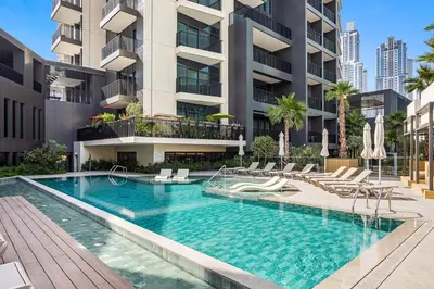 a swimming pool with chairs and a building at 5 min to Metro - New 1 Bed in Business Bay in Dubai