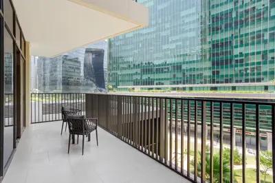 a balcony with two chairs and a table in a building at 5 min to Metro - New 1 Bed in Business Bay in Dubai