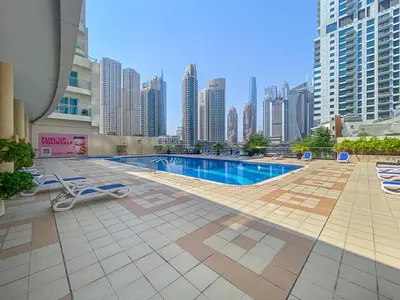 a pool in the middle of a city with tall buildings at StoneTree - Newly Furnished - Near Metro in Dubai