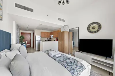 a bedroom with a large white bed and a tv at StoneTree - Newly Furnished - Near Metro in Dubai
