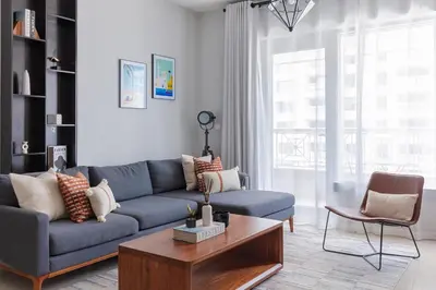 a living room with a blue couch and a coffee table at Your 2BR with Burj Khalifa View in Dubai