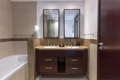 a bathroom with two sinks and a bath tub at Your 2BR with Burj Khalifa View in Dubai