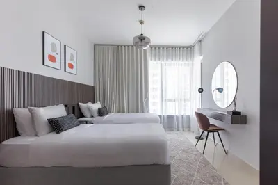 a hotel room with two beds and a desk at Your 2BR with Burj Khalifa View in Dubai