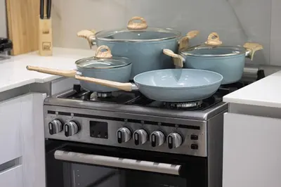 two pots and pans sitting on top of a stove at 1-Bed in Binghatti Crescent, Next to Circle Mall in Dubai