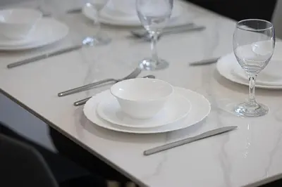 a table with white plates and wine glasses on it at 1-Bed in Binghatti Crescent, Next to Circle Mall in Dubai