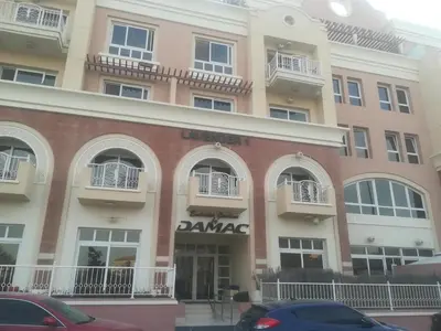 a building with a parking lot in front of it at Lavender Oasis - Entire Spacious 1 flat in Jumeirah Village Circle in Dubai