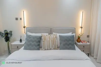 a bedroom with a bed with pillows and two lamps at Clever Guest 025 Dubai Gate 1 in Dubai