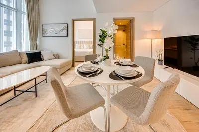 a living room with a white table and chairs at Cozy 2 bedroom apartment in Dubai Marina in Dubai