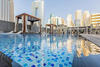 a swimming pool with blue tiles in a city at Cozy 2 bedroom apartment in Dubai Marina in Dubai