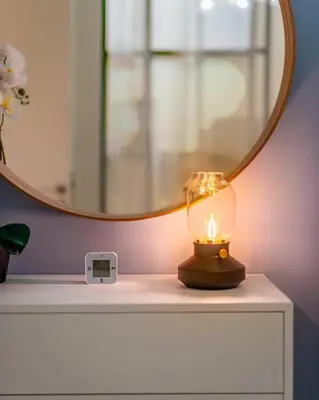 a lamp sitting on a table with a mirror at GuestReady - Sky-High Comfort at Dubai Hills in Dubai