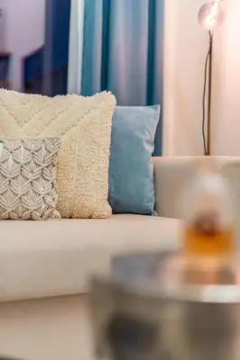 a white couch with a blue pillow on it at GuestReady - Sky-High Comfort at Dubai Hills in Dubai