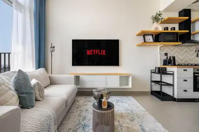 a living room with a white couch and a tv at GuestReady - Sky-High Comfort at Dubai Hills in Dubai