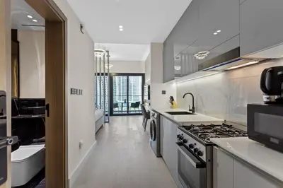 a kitchen with a sink and a stove top oven at Studio Retreat with Canal and Burj Khalifa Views in Dubai