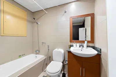 a bathroom with a toilet and a sink and a tub at StoneTree - Stunning Lake View - Spacious in Dubai