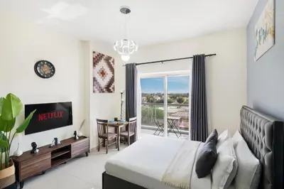 a bedroom with a bed and a view of a balcony at Stylish Studio Urban Retreat in Dubai