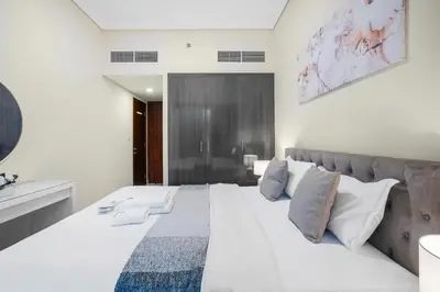 a bedroom with a large bed with white sheets and pillows at StoneTree - Cozy 1 BR - Near Metro in Dubai