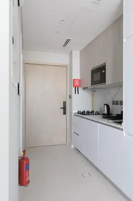a kitchen with a door in the middle of a room at Cozy Studio in Westwood By IMTIAZ in Dubai