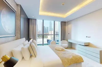 a bedroom with a white bed and a large window at The Sterling - Modern One Bedroom in Dubai