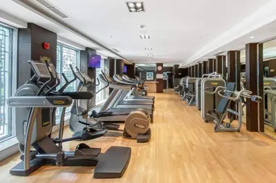 a gym with a row of treadmills and ellipticals at Prime Downtown 2BR Retreat in Dubai