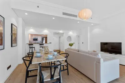 a dining room and living room with a table and a couch at Exquisite 1BR with Private beach in Palm Jumeirah in Dubai