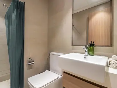 a bathroom with a sink and a toilet and a mirror at Spacious 2BR with Big Balcony In Meydan in Dubai