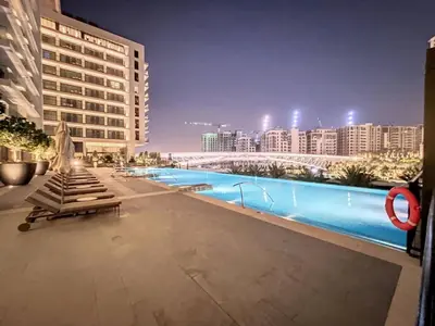 a swimming pool in the middle of a city at night at Palace Residences - Inviting One Bedroom in Dubai