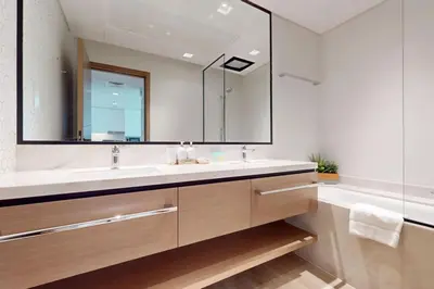 a bathroom with a sink and a mirror and a tub at Palace Residences - Inviting One Bedroom in Dubai