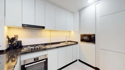a kitchen with white cabinets and a sink at Locations I Uni Estate Supreme Residence I Luxury 1BR I Near Miracle Garden I Pool, Gym & Parking in Dubai