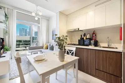 a kitchen and living room with a table and a counter at LUXE | 1BR | Close to Burj Khalifa & Dubai Mall in Dubai