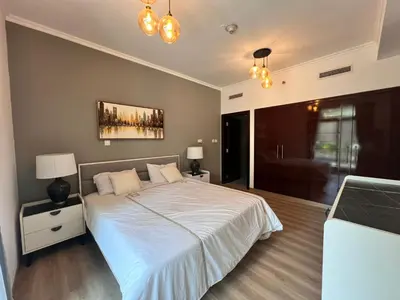 a bedroom with a large white bed with two lamps at Luxurious 1BR in Burj Views Podium, Downtown in Dubai
