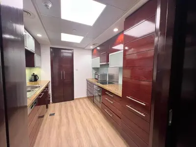 a large kitchen with wooden cabinets and a skylight at Luxurious 1BR in Burj Views Podium, Downtown in Dubai