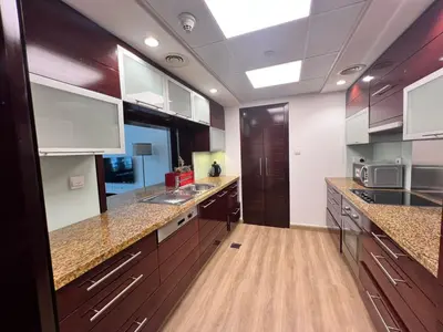 a large kitchen with wooden counters and a ceiling at Luxurious 1BR in Burj Views Podium, Downtown in Dubai