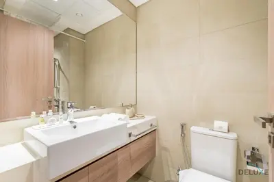 a bathroom with a sink and a toilet and a mirror at Stylish Studio Apartment in Azizi Riviera 37 Al Merkadh by Deluxe Holiday Homes in Dubai