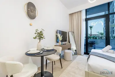 a bedroom with a bed and a table and chairs at Stylish Studio Apartment in Azizi Riviera 37 Al Merkadh by Deluxe Holiday Homes in Dubai