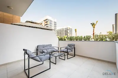 a group of chairs sitting on a balcony at Stylish Studio Apartment in Azizi Riviera 37 Al Merkadh by Deluxe Holiday Homes in Dubai
