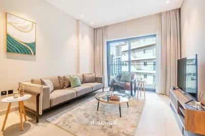 a living room with a couch and a tv at Manzil - 1BR Apartment in Marquis Signature with City Views in Dubai