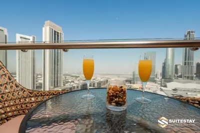 two glasses of orange juice and a bowl of nuts on a table at Emaar Residence Fashion Avenue in Dubai