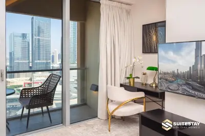 a living room with a desk and chair and a window at Emaar Residence Fashion Avenue in Dubai