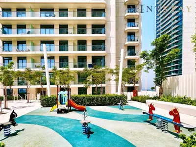 a playground in front of a tall building at Marina Vista 2, Emaar Beachfront - Mint Stay in Dubai