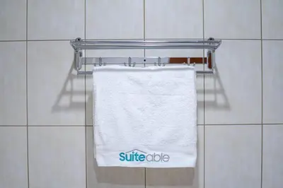 a white towel hanging on a towel rack in a bathroom at Peaceful flat in Motor City in Dubai