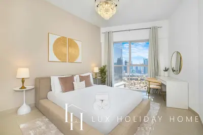 a bedroom with a large white bed and a couch at LUX The Executive Burj Khalifa View Suite in Dubai