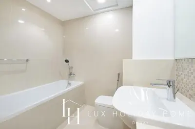 a bathroom with a sink and a tub and a toilet at LUX The Executive Burj Khalifa View Suite in Dubai